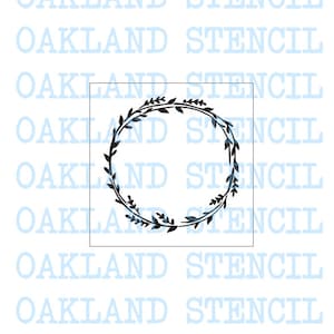 May include: A stencil design featuring a circular wreath composed of leaves and branches. The wreath is black with subtle blue accents, set within a square frame. The background includes the repeated text "OAKLAND STENCIL" in a light blue color.