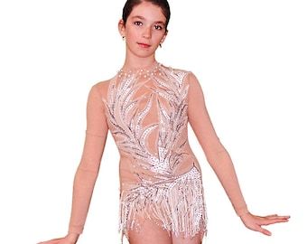 May include: A nude-colored leotard with a long-sleeved design. The leotard features a silver and white leaf pattern with rhinestones and a fringe trim.