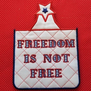 May include: White fabric with a blue star and the text "FREEDOM IS NOT FREE" embroidered in red and blue thread.