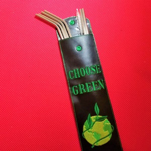 Puede incluir: Una funda de transporte de cuero negro con cierre de cremallera y un diseño bordado en verde que dice "CHOOSE GREEN" y presenta una vid verde envuelta alrededor de un globo amarillo. La funda contiene un juego de pajitas para beber de acero inoxidable.