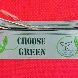 May include: A gray zippered pouch with the text "CHOOSE GREEN" embroidered on the front. The pouch has a green leaf design and a whale tail design with a blue wave. The pouch contains two metal straws and a cleaning brush.