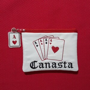 May include: White zippered pouch with an embroidered design of four aces and the word "Canasta".