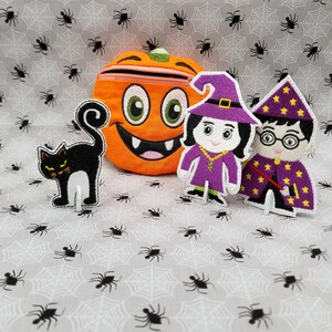 May include: A set of Halloween-themed felt finger puppets. The set includes a black cat, a witch with a purple dress and a wizard with a yellow and purple robe. There is also a felt pumpkin with a zipper.