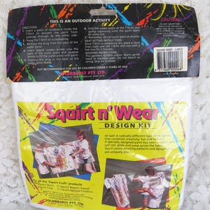May include: A Squirt n' Wear Design Kit, a creative outdoor activity for children. The kit includes a T-shirt, water pistol, and paint. The packaging features images of children decorating shirts with colorful paint. Not suitable for children under 3.