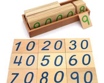 May include: A set of wooden number tiles with blue numbers on a light wood background. The numbers are arranged in order from 10 to 90. The tiles are in a wooden box with green numbers on the top.