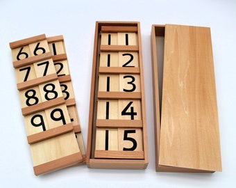 May include: Wooden box with a set of number tiles. The tiles are arranged in rows, with the numbers 1 through 5 on the top row, 6 through 9 on the second row, and 10 through 15 on the third row.