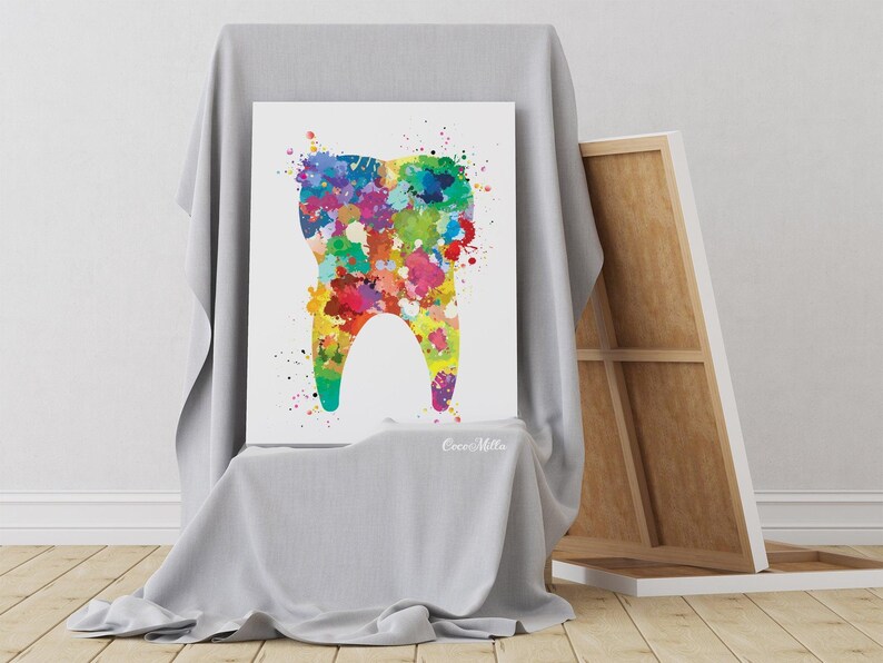 May include: A colorful watercolor painting of a tooth. The tooth is filled with vibrant paint splatters in shades of blue, green, yellow, red, and purple. The artwork is displayed on a white canvas, leaning against a draped surface.