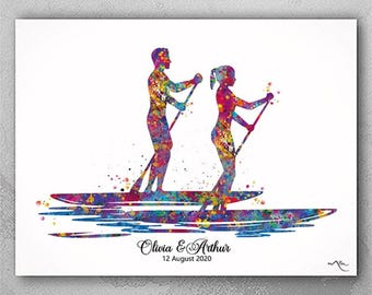 Könnte beinhalten: Ein Aquarellbild eines Paares beim Paddelsurfen. Das Paar ist in einem farbenfrohen, abstrakten Stil silhouettiert. Der Text "Olivia & Arthur 12. August 2020" befindet sich am unteren Rand des Bildes.