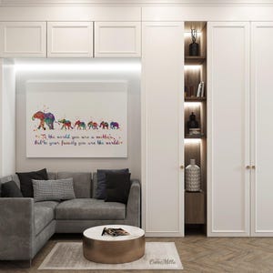 May include: A watercolor painting of a line of elephants with the text "To the world you are a mother, but to your family you are the world." The painting is framed and hanging on a white wall in a living room setting.