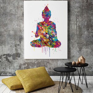May include: A colorful watercolor painting of a seated Buddha figure. The artwork features a vibrant mix of colors, including blue, yellow, red, and green, with paint splatter effects. The image is displayed on a white canvas, mounted on a gray wall.