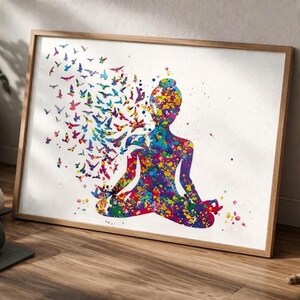 May include: A framed watercolour print shows a meditating figure in a lotus position, made of colourful paint splatters. Birds in various colours are emerging from the figure's head. The artwork is set against a white background.