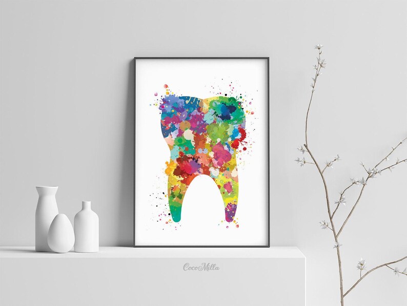 May include: A framed print featuring a colorful watercolor illustration of a tooth. The tooth is filled with vibrant splashes of red, yellow, blue, and green. The artwork is displayed on a white shelf with minimalist white vases.