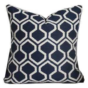 May include: A navy blue cushion with a white geometric pattern. The pattern is a repeating design of hexagons.