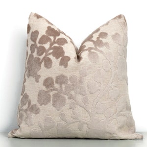 Peut inclure: Un coussin beige avec un motif floral dans une nuance de beige plus foncée. Le coussin est fait d'un tissu doux et velouté.