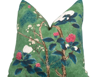 May include: Green throw pillow with a floral pattern featuring white, pink, and blue flowers on a green background.
