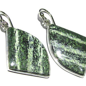 Puede incluir: Un par de pendientes de plata con detalles de piedra rayada en verde y blanco.