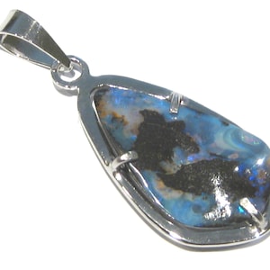 Op de afbeelding: Zilveren hanger met een traanvormige opaal edelsteen. De opaal heeft een mix van blauwe, zwarte en witte kleuren. De hanger heeft een zilveren balein om aan een ketting te bevestigen. De edelsteen is gezet in een zilveren bezel.