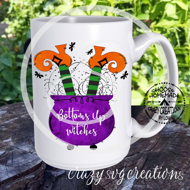 Puede incluir: Taza de cer&aacute;mica blanca con un caldero morado y dos piernas de bruja que sobresalen de la parte superior. El caldero tiene el texto "Bottoms Up Witches". La taza tiene un asa negra y un fondo blanco.