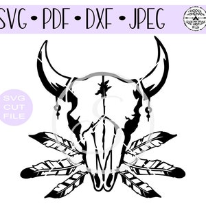 以下が含まれることがあります： 黒と白のシルエットの雄牛の頭蓋骨で、両側に3本の羽根がついています。頭蓋骨は額に装飾的なデザインが施され、両側にビーズの垂れ下がりが付いています。画像の左側には円の中に「SVG CUT FILE」というテキストがあります。