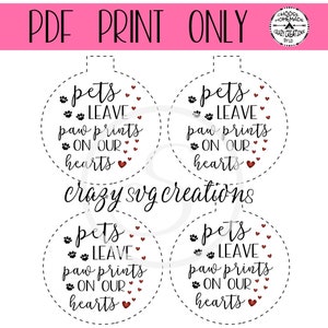 May include: Four printable ornament designs with a black and white paw print and the text "pets leave paw prints on our hearts".