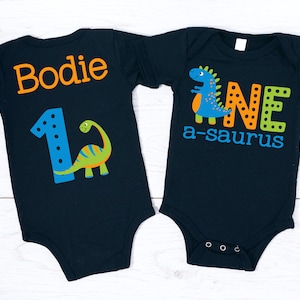 Dinosaurier 1.Geburtstags-Junge auf schwarzem Hemd - erster Geburtstag, ein Saurus Rex, Geburtstagsbodysuit, blaugrün-orange, Dinosaurier-Geburtstagshemd
