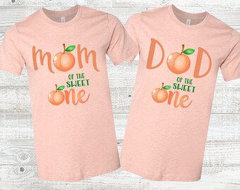 Peut inclure: Deux t-shirts couleur pêche avec un graphique de pêche et le texte "Maman du petit chéri" et "Papa du petit chéri".