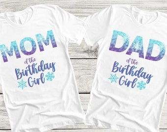 May include: Two white t-shirts with a blue and purple ombre design. The left shirt says "MOM of the Birthday Girl" with snowflakes. The right shirt says "DAD of the Birthday Girl" with snowflakes.