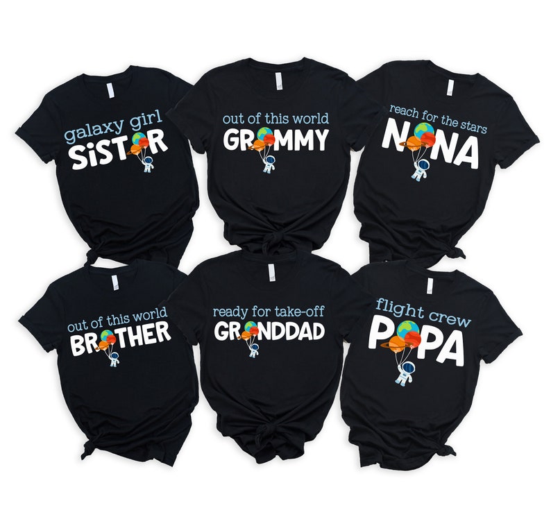 May include: Six black t-shirts with white text and a cartoon astronaut holding balloons. The shirts read: "galaxy girl SISTER", "out of this world GROMMY", "reach for the stars NONA", "out of this world BROTHER", "ready for take-off GRANDDAD", and "flight crew PAPA".
