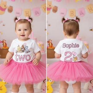 May include: A toddler in a white t-shirt with a Winnie the Pooh graphic and the word "two", paired with a pink tutu and shoes. The background features party decorations, including balloons and banners, celebrating a second birthday.
