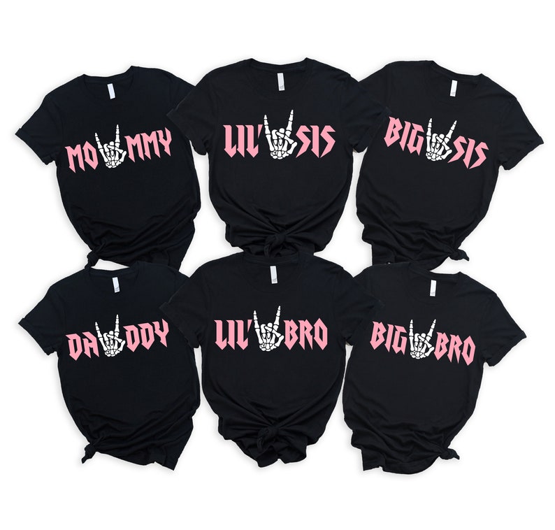 May include: Six black t-shirts with pink text and a skeleton hand making a rock and roll sign. The shirts say "Mommy", "Lil' Sis", "Big Sis", "Daddy", "Lil' Bro", and "Big Bro".