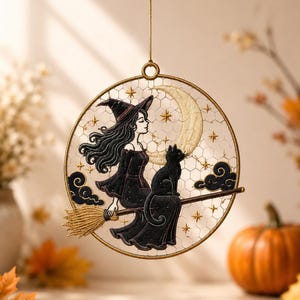 Peut inclure: Une décoration suspendue circulaire présentant une broderie complexe d'une sorcière en robe noire et chapeau pointu chevauchant un balai avec un chat noir. Le motif inclut un grand croissant de lune, des étoiles dorées et des nuages sur un filet.