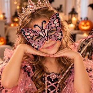 May include: A pink and black butterfly mask with intricate lace-like patterns, worn with a matching pink crown featuring embedded crystals. A wand with a pink butterfly topper and black lace ribbons is held, alongside a pink dress with ruffled layers.