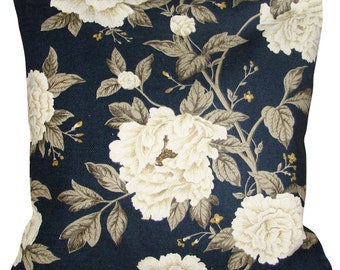 May include: A square throw pillow featuring a dark navy blue background with a repeating pattern of large, cream-colored peony flowers and grey-green foliage. The text "Pretty Cushions" is printed in black in the bottom right corner.