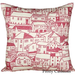 May include: A red and white throw pillow with a repeating pattern of houses and trees. The pillow is made of a soft, linen-like fabric. "Pretty Cushions" is printed in the bottom right corner.