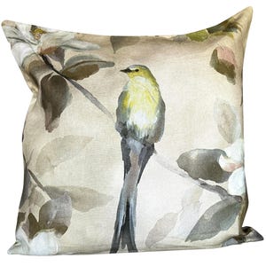 May include: Square cushion with a watercolour design featuring a yellow and grey bird perched on a branch. The cushion has a neutral background with floral and leaf accents in shades of brown, grey, and white. The cushion is a square shape.