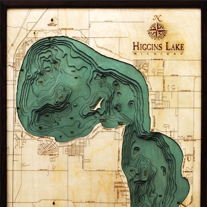 K&ouml;nnte beinhalten: Eine Holzkarte des Higgins Lake in Michigan, die die Tiefenkonturen des Sees in Gr&uuml;n zeigt. Die Karte ist in einem dunklen Holzrahmen gerahmt. Der Text "Higgins Lake, Michigan" ist in der oberen rechten Ecke der Karte gedruckt.