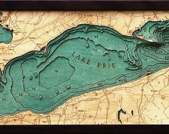 May include: A framed wooden bathymetric map of Lake Erie featuring layered teal water depths and natural wood land topography. The map includes depth markers, a compass rose, and labels for Lake Erie, Lake St. Clair, and Canada.