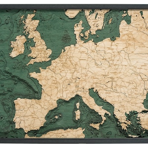 May include: A detailed wooden map of Europe with a green ocean and brown land. The map shows the borders of each country and major cities.
