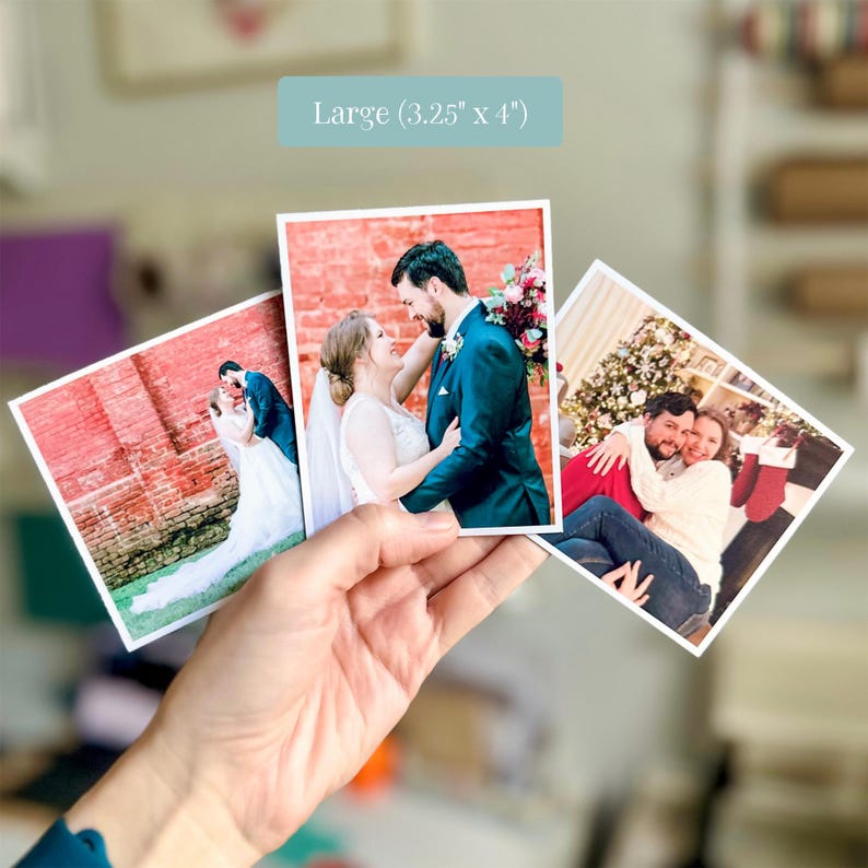 Pu&ograve; includere: Tre stampe fotografiche quadrate con ritratti di matrimoni e festivit&agrave;. La stampa centrale mostra una coppia in abiti formali davanti a un muro di mattoni rossi. Un'etichetta sopra riporta Large (3,25" x 4"). Le stampe sono tenute a ventaglio.