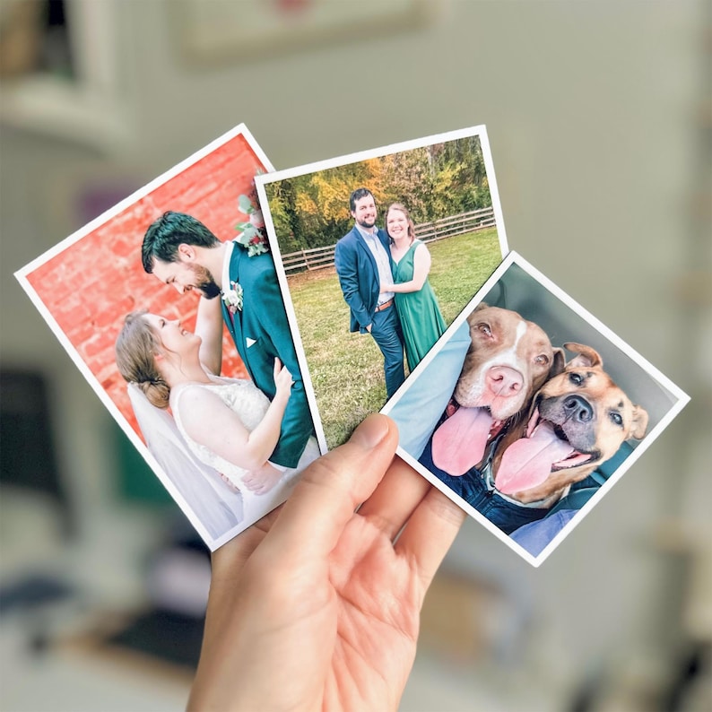 Pu&ograve; includere: Tre stampe fotografiche quadrate con bordi bianchi. Una mostra una coppia in abiti nuziali davanti a un muro di mattoni rossi, un'altra una coppia in abiti formali in un prato, e la terza due cani marroni con la lingua di fuori.