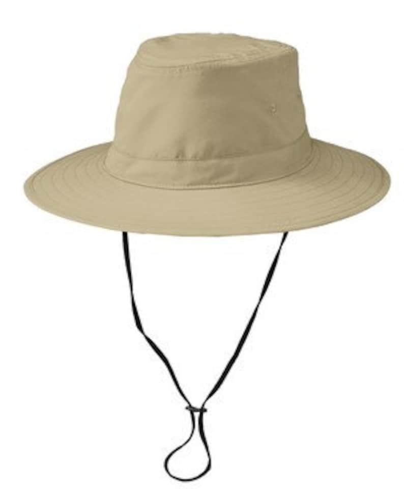 May include: A beige sun hat with a wide brim and a black chin strap.
