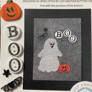 May include: Halloween-themed cross-stitch pattern featuring a ghost and pumpkin. Includes decorative buttons spelling "BOO" and other Halloween-themed embellishments. The text reads "Halloween Spells #2".