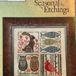 May include: A cross-stitch pattern featuring four seasonal scenes: a rabbit in a field of flowers, fish swimming in water, owls in a forest, and a cardinal in a snowy landscape. The pattern is titled "Seasonal Etchings" and is from the Heart in Hand needle art collection.
