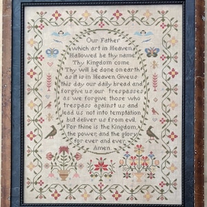 May include: A framed cross-stitch sampler with a floral border and the Lord's Prayer in a traditional font. The text reads "Our Father which art in Heaven, hallowed be thy name. Thy Kingdom come. Thy will be done on earth as it is in Heaven. Give us this day our daily bread and forgive us our trespasses as we forgive those who trespass against us and lead us not into temptation, but deliver us from evil. For thine is the Kingdom, the power, and the glory for ever and ever. Amen."