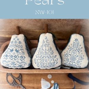 May include: Three blue and white embroidered pear-shaped pillows with a wooden tray and a pair of scissors. The pillows have different designs, including a floral pattern, a pattern with the alphabet, and a pattern with a bird and a heart. The tray is made of wood and has a natural finish. The scissors are made of metal and have a black handle.