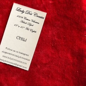 May include: A white card with black text that reads "Lady Dot Creates", "100% Cotton Velveteen", "Hand-Dyed", "18" x 10" Fat Eighth", "CHILI", "Follow us on Instagram", "elegantstitch.ladydotcreates", "www.ladydotcreates.com", and "ladydotcreates@gmail.com".