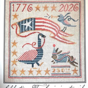 May include: Cross-stitch design celebrating America's 250th birthday. Features the American flag, a goose, a bird, and a rabbit, with the years 1776 and 2026. The text reads "America's Grand Celebration!" and "Celebrating The Semiquincentennial America's 250th Birthday!"
