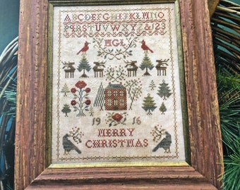 May include: A cross-stitch sampler titled "Christmas Rose" with a red and green color scheme. The sampler features a house, trees, birds, and the text "Merry Christmas". It is part of the "Blackbird Designs" Christmas Sampler Series.