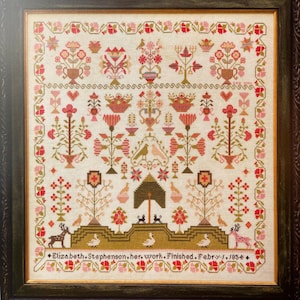 May include: A framed cross-stitch sampler featuring a floral design in shades of red, pink, and green. The sampler is titled "Elizabeth Stephenson, her work, finished, Febry. 1, 1854."