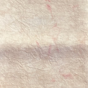 May include: A close-up of a white linen fabric with several faint pink stains.